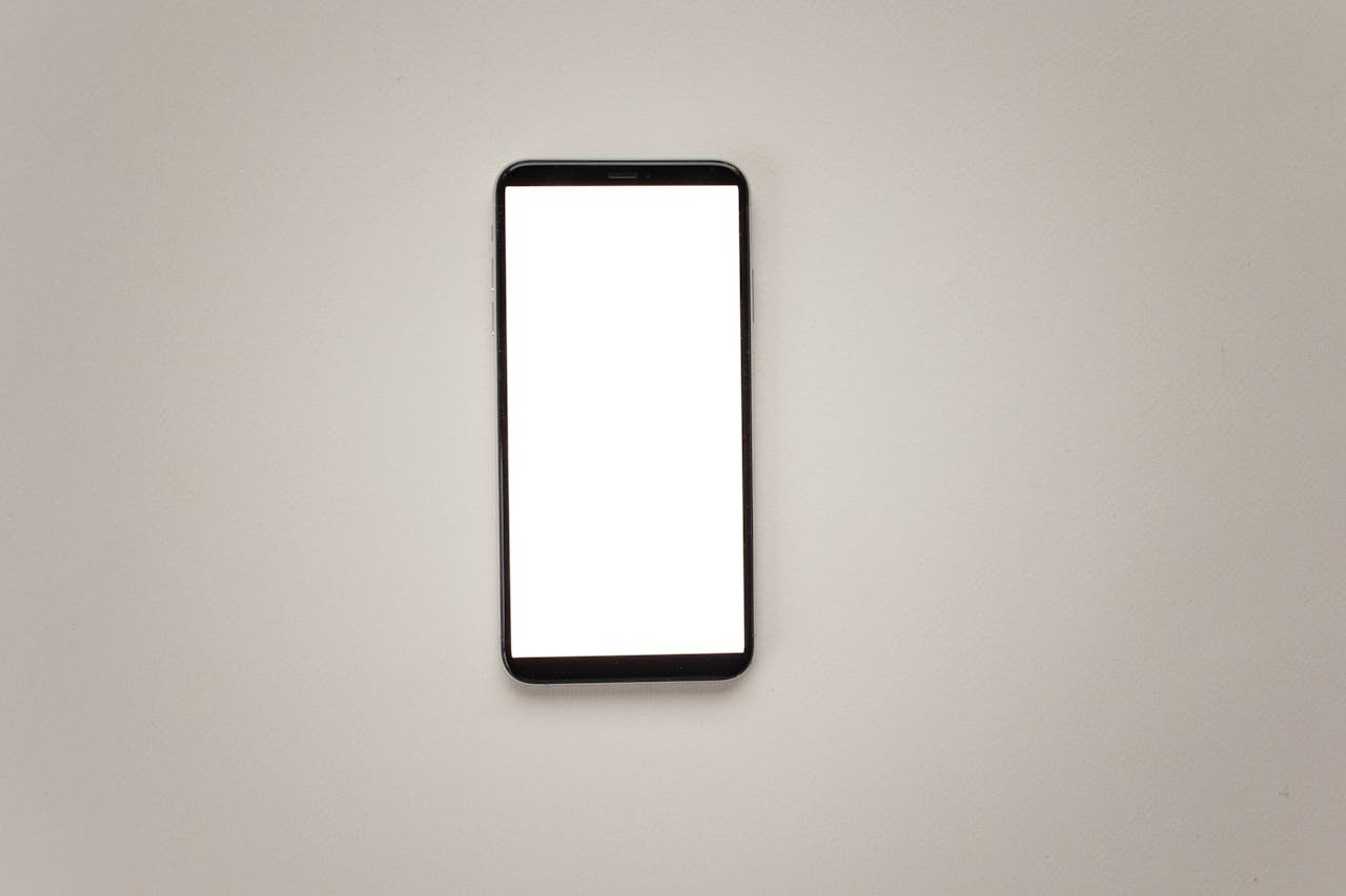 Top view of a smartphone with a blank screen for mockup design on a neutral background.