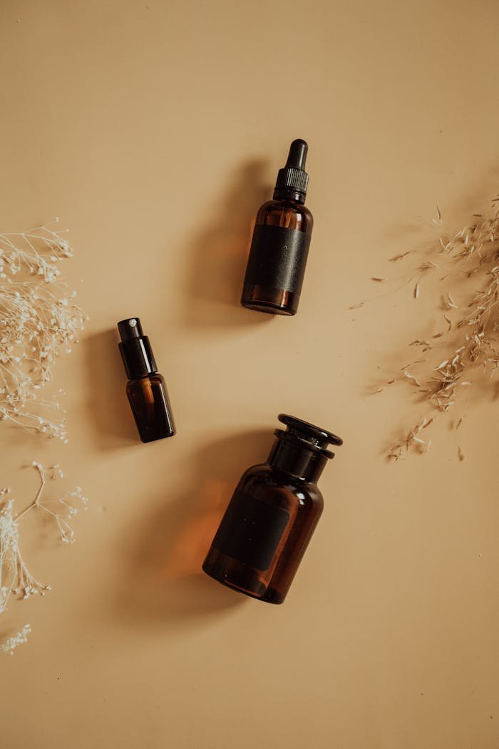 services-02 Stylish flat lay of amber bottles with dry floral accents, perfect for beauty product presentation.